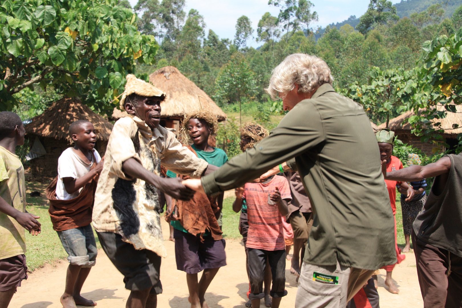 A tourist enjoys a cultural dance with the Batwa community of Semuliki National Park